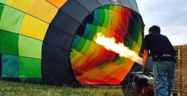 Fase di preparazione e gonfiaggio di una mongolfiera colorata al mattino presto
